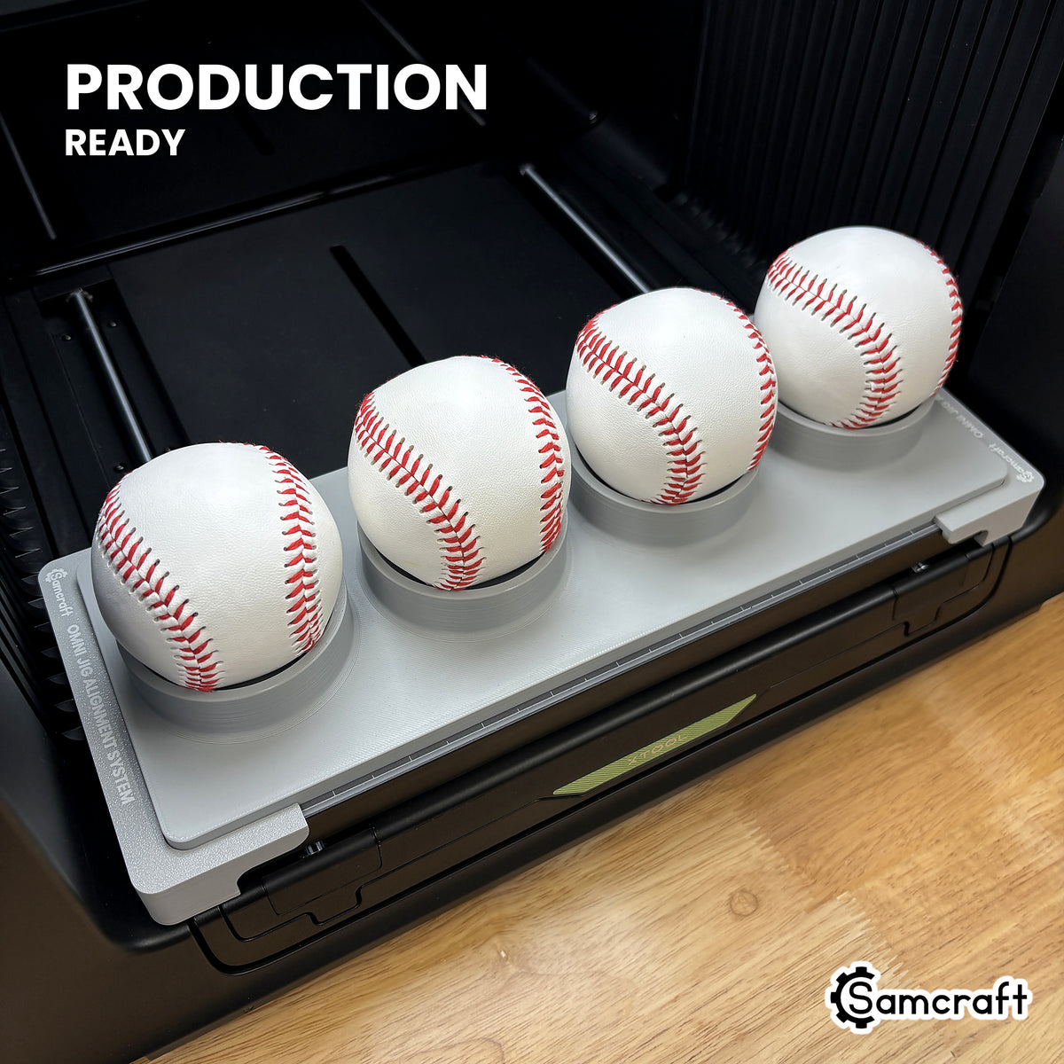 Samcraft baseball jig holding four baseballs on the xTool Omni UV printer bed, set up for production runs.
