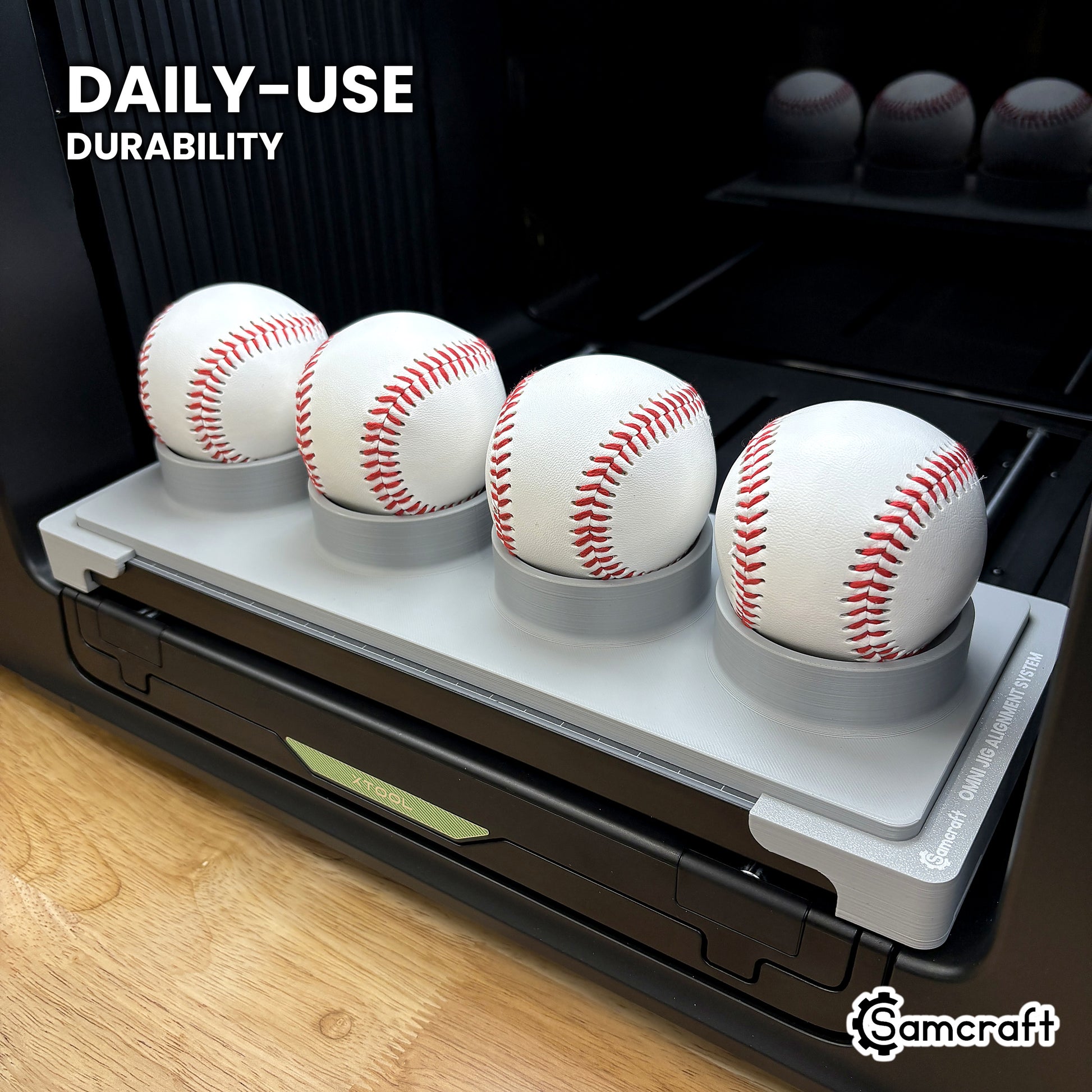 Samcraft baseball jig in high-temperature rated plastic holding four baseballs on the xTool Omni bed, built for daily-use durability.