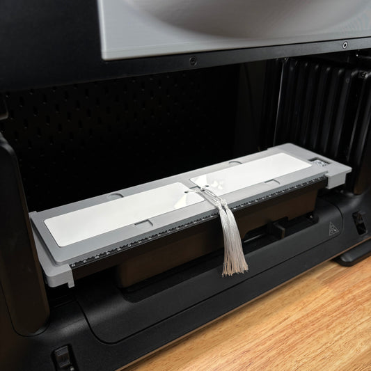 Samcraft 2x6 bookmark jig on the eufyMake E1 print bed, holding a metal bookmark with a tassel hanging over the edge.