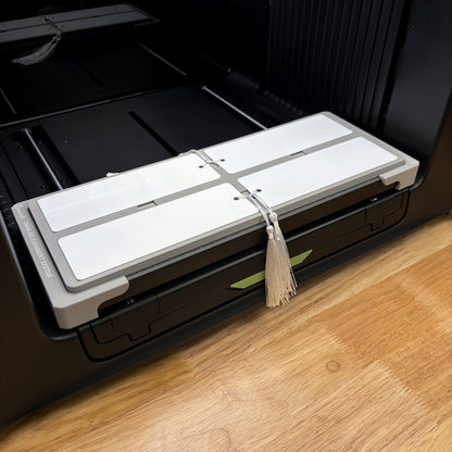 Samcraft bookmark jig on the bed of an xTool Omni UV printer, loaded with four 2x6 inch bookmarks.