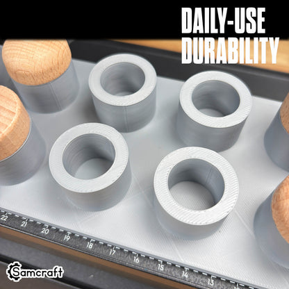 Top view of the Samcraft Bottle Stopper Jig's durable gray cylindrical recesses holding wood-topped bottle stoppers with built-in alignment ruler on the eufyMake E1.