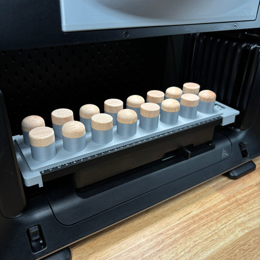 Samcraft bottle stopper jig on the eufyMake E1 print bed, holding a row of wood-topped bottle stoppers upright.
