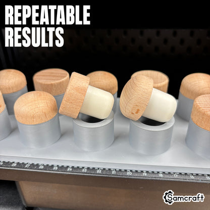 Close-up of wood-topped bottle stoppers seated in the Samcraft Bottle Stopper Jig, fitting different stopper styles for repeatable results on the eufyMake E1.
