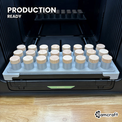 Samcraft bottle stopper jig loaded with twenty-four stoppers on the xTool Omni UV printer bed, set up for production runs.