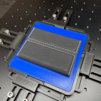 Samcraft blue business card case jig on a ComMarker laser bed, holding a black stitched leatherette card case.