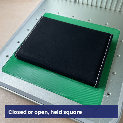 Black leatherette business card case held closed in the Samcraft jig, ready to engrave.