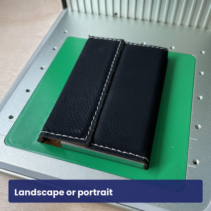 Two black leatherette business card cases on the Samcraft jig, showing landscape and portrait layouts.