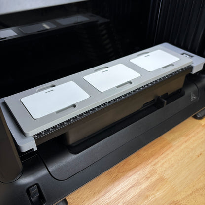 Samcraft Business Card Jig holding three blank white metal business cards on the eufyMake E1 UV printer bed