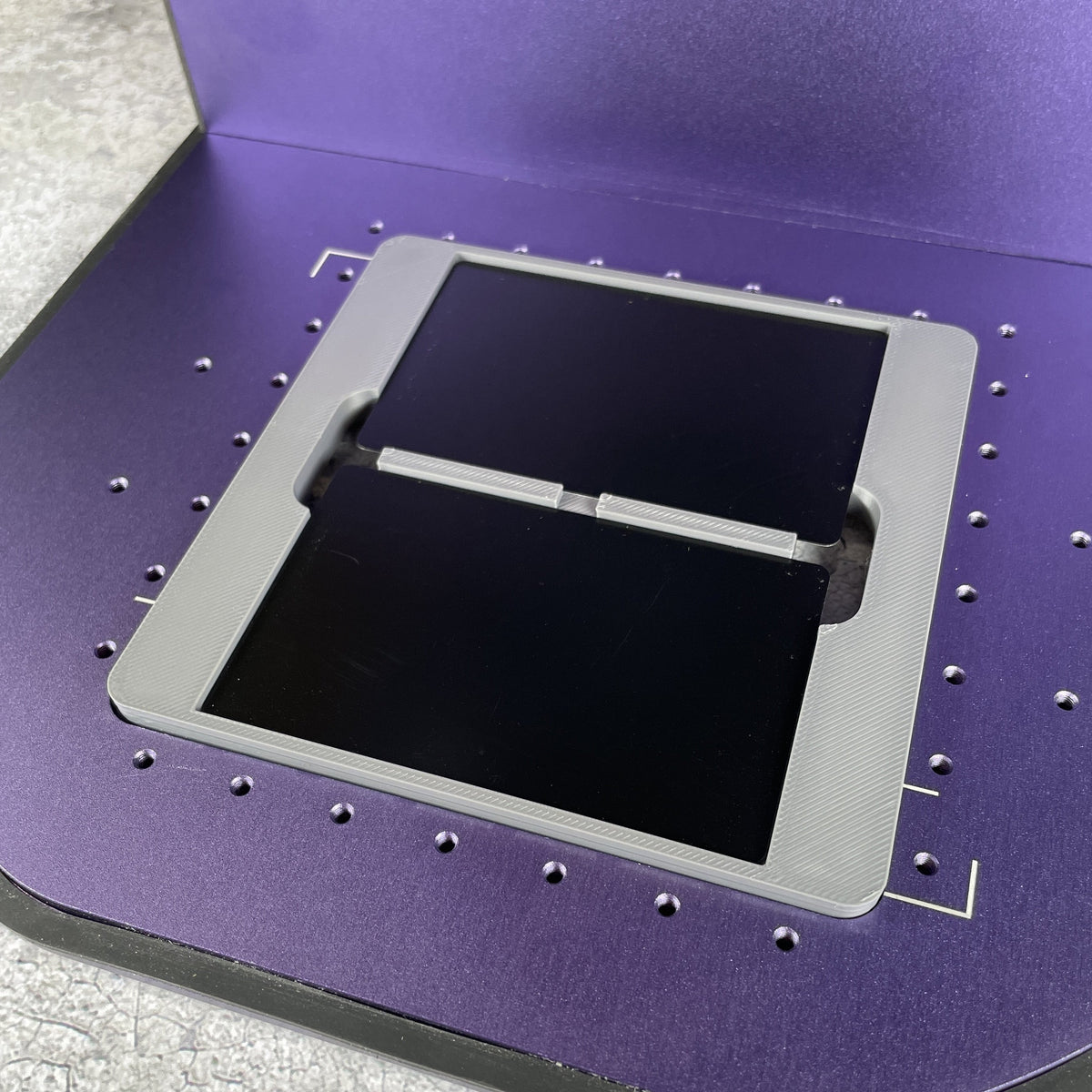 Samcraft business card jig on the purple bed of a WeCreat Lumos, holding a black metal business card.