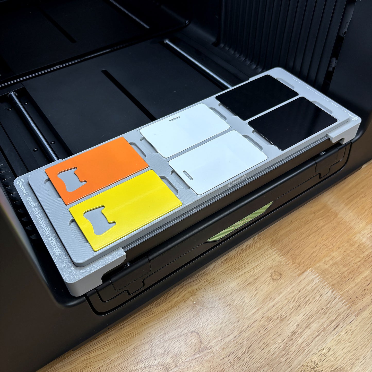 Samcraft business card jig on the bed of an xTool Omni UV printer, holding six CR80 card blanks in two rows of three.