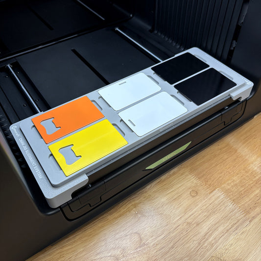 Samcraft business card jig on the bed of an xTool Omni UV printer, holding six CR80 card blanks in two rows of three.