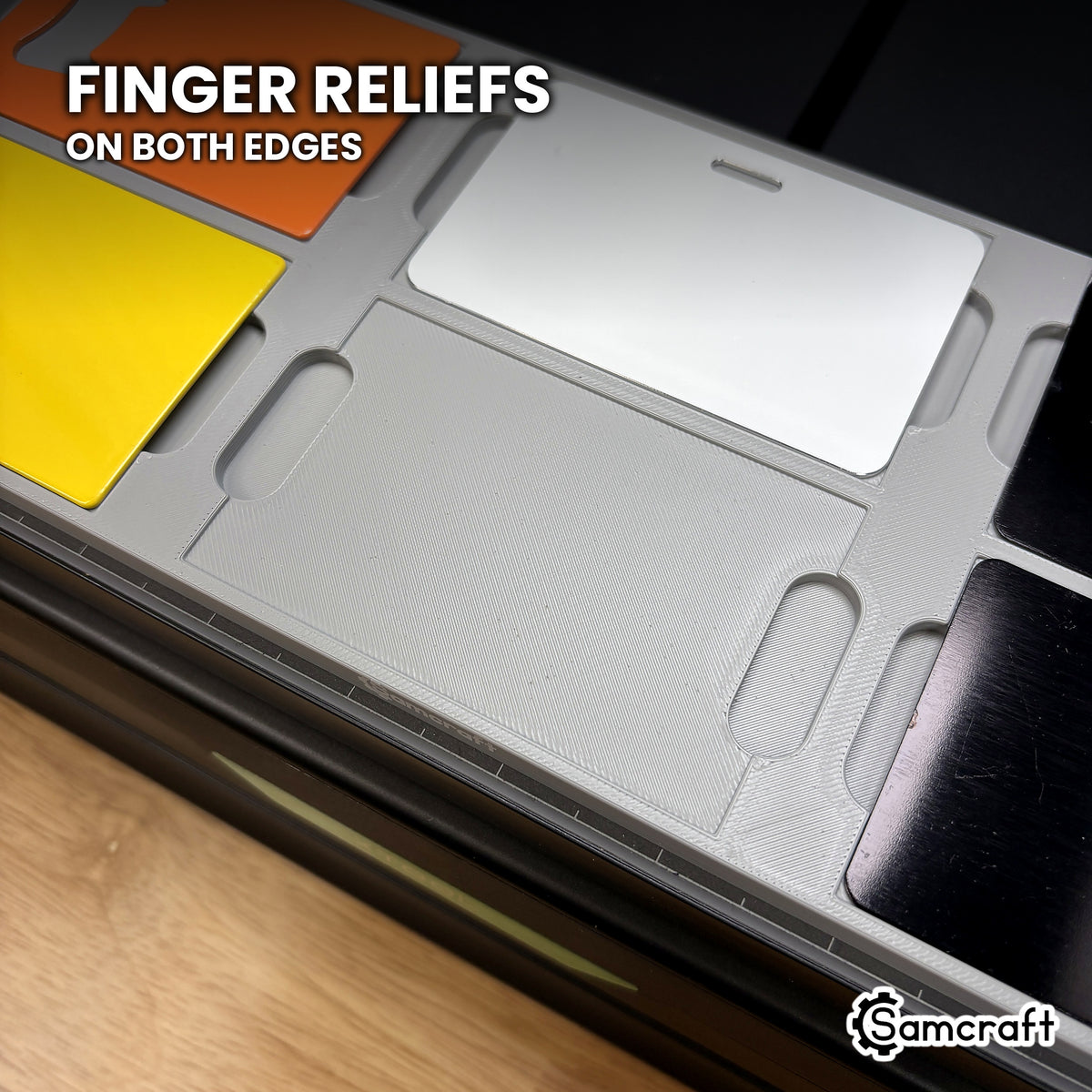 Close-up of an empty pocket in the Samcraft xTool Omni card jig, showing the obround finger reliefs on both card edges.