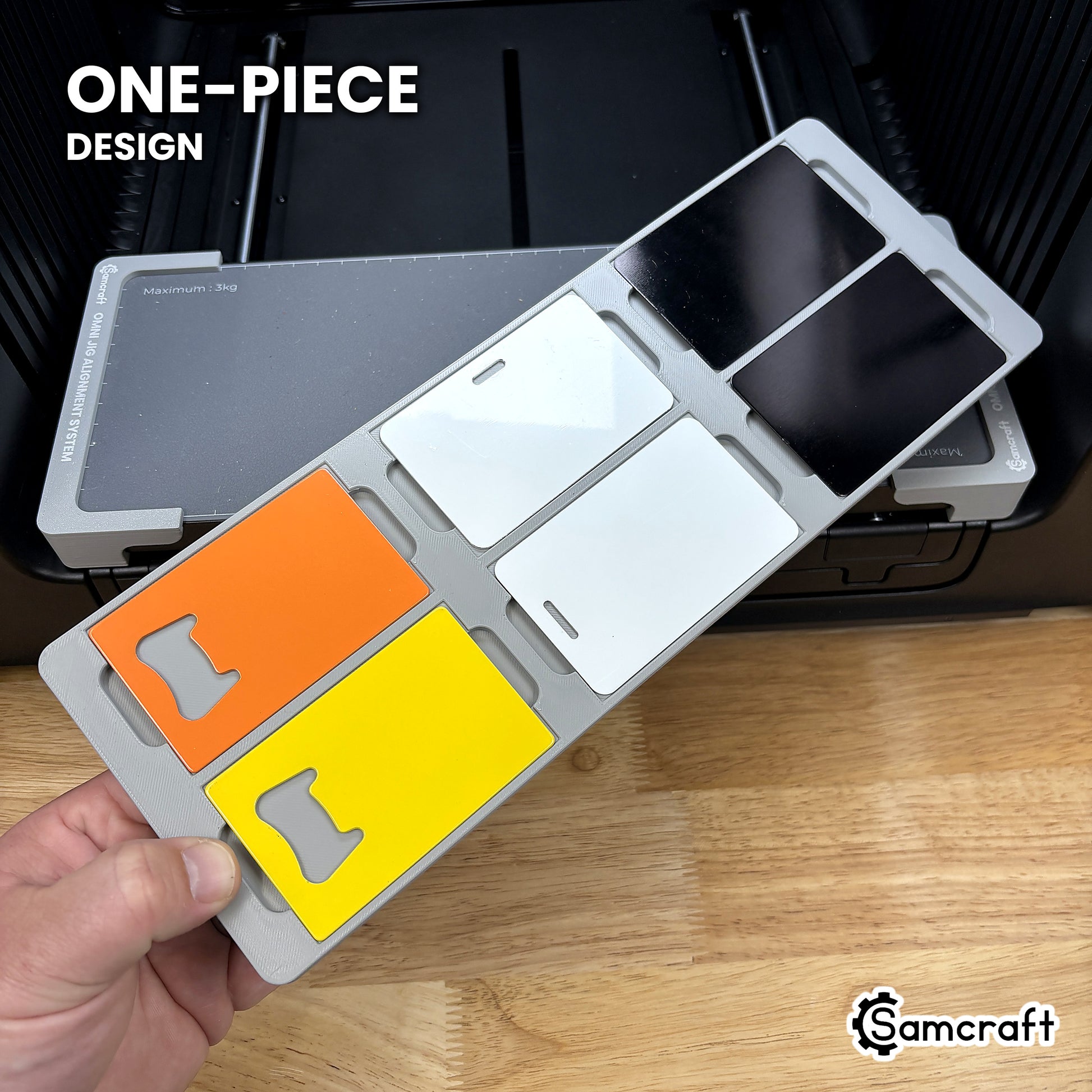 Hand holding the one-piece Samcraft business card jig for the xTool Omni, six card blanks seated in a single molded gray tray.