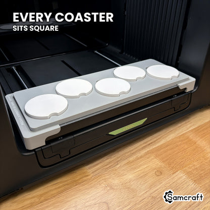 Every car coaster seated square in its own recess across the Samcraft xTool Omni jig, for consistent print placement.