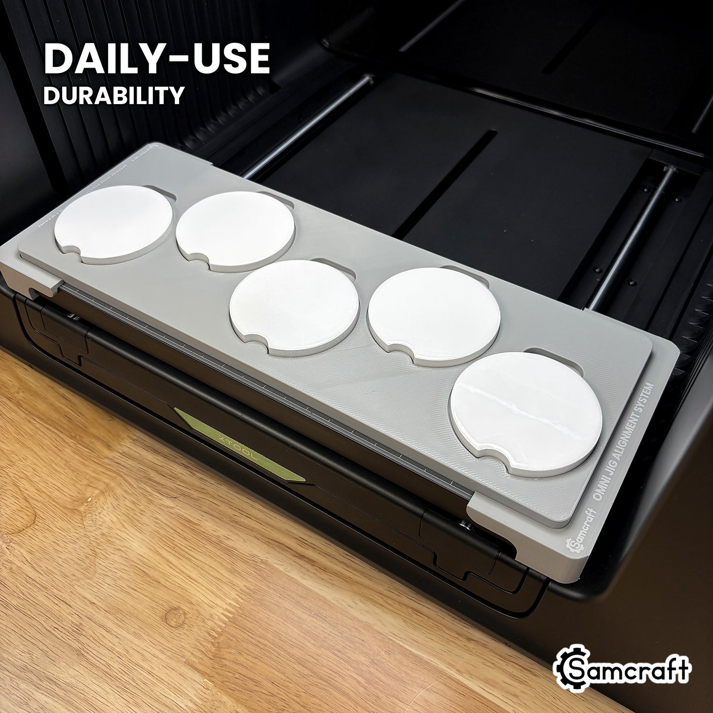 Samcraft car coaster jig in high-temperature rated plastic holding five coasters on the xTool Omni bed, built for daily-use durability.