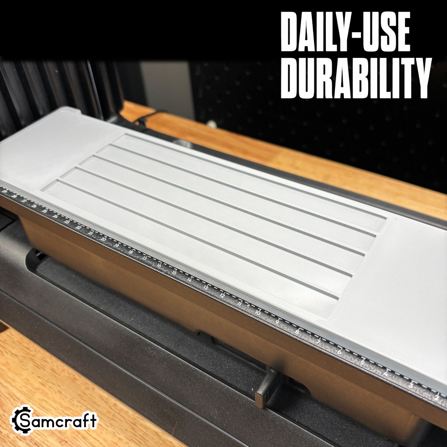 Empty Samcraft Carpenter Pencil Jig showing the durable gray tray with parallel recessed channels and built-in ruler, mounted on the eufyMake E1 UV printer.