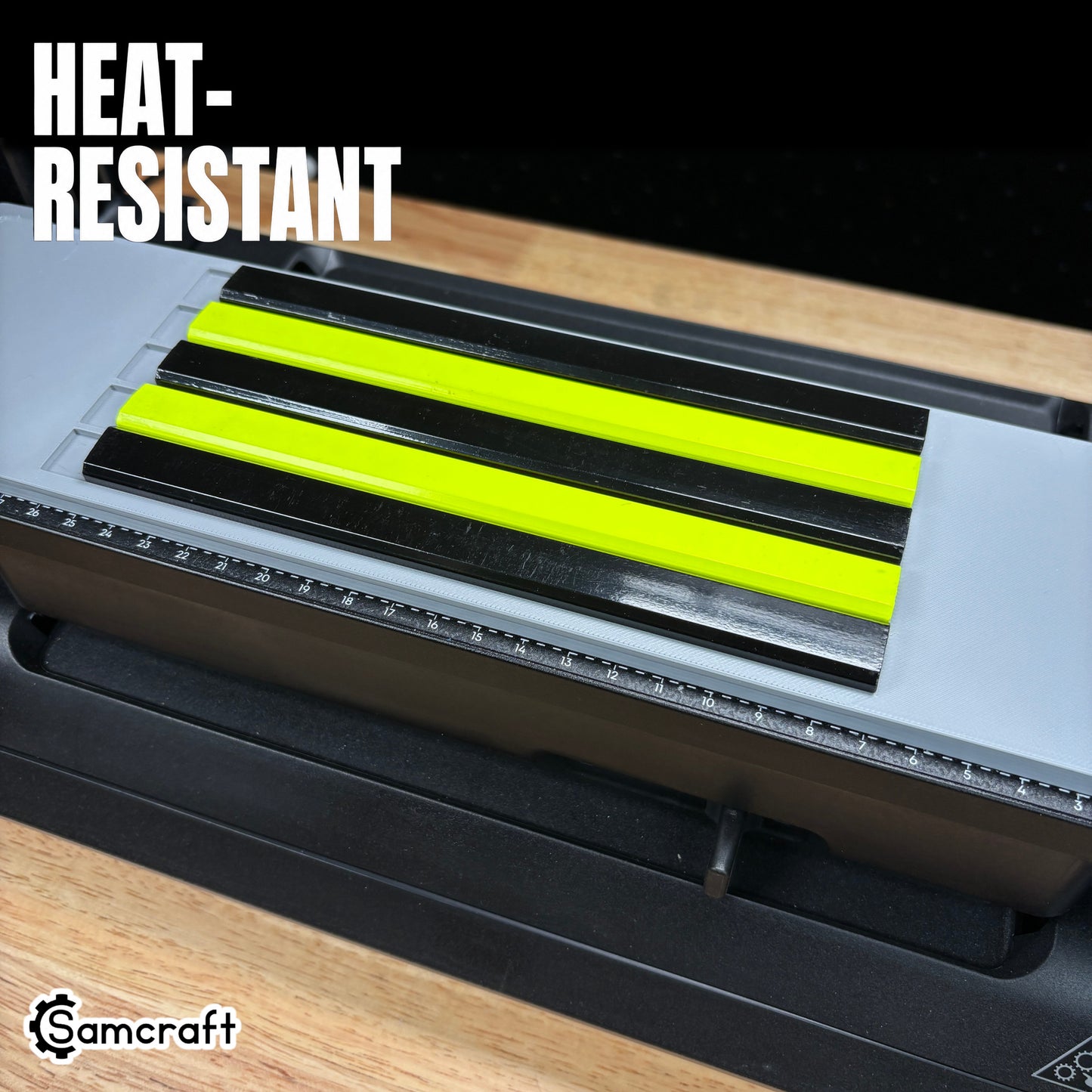 Heat-resistant Samcraft Carpenter Pencil Jig holding five black and neon yellow carpenter pencils in gray channels with alignment ruler on the eufyMake E1 UV printer.