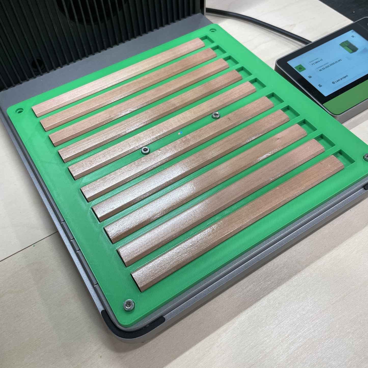 Samcraft green carpenter pencil jig in an xTool F1 Ultra laser bed, holding a row of flat wooden carpenter pencils.