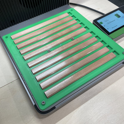 Samcraft green carpenter pencil jig in an xTool F1 Ultra laser bed, holding a row of flat wooden carpenter pencils.