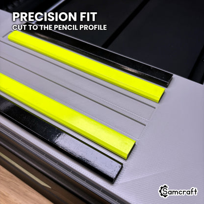 Close-up of the recessed channels in the Samcraft carpenter pencil jig, with black and neon yellow carpenter pencils seated beside empty channels cut to the pencil profile.