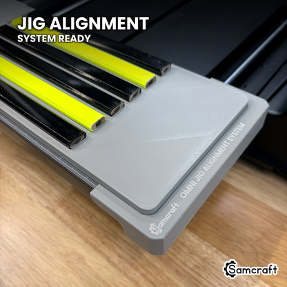 Corner of the Samcraft Omni Jig Alignment System with the carpenter pencil jig seated in it and the OMNI JIG ALIGNMENT SYSTEM marking clearly visible.
