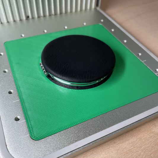 Samcraft compact mirror jig in an xTool F1 laser bed, holding a round black compact mirror.