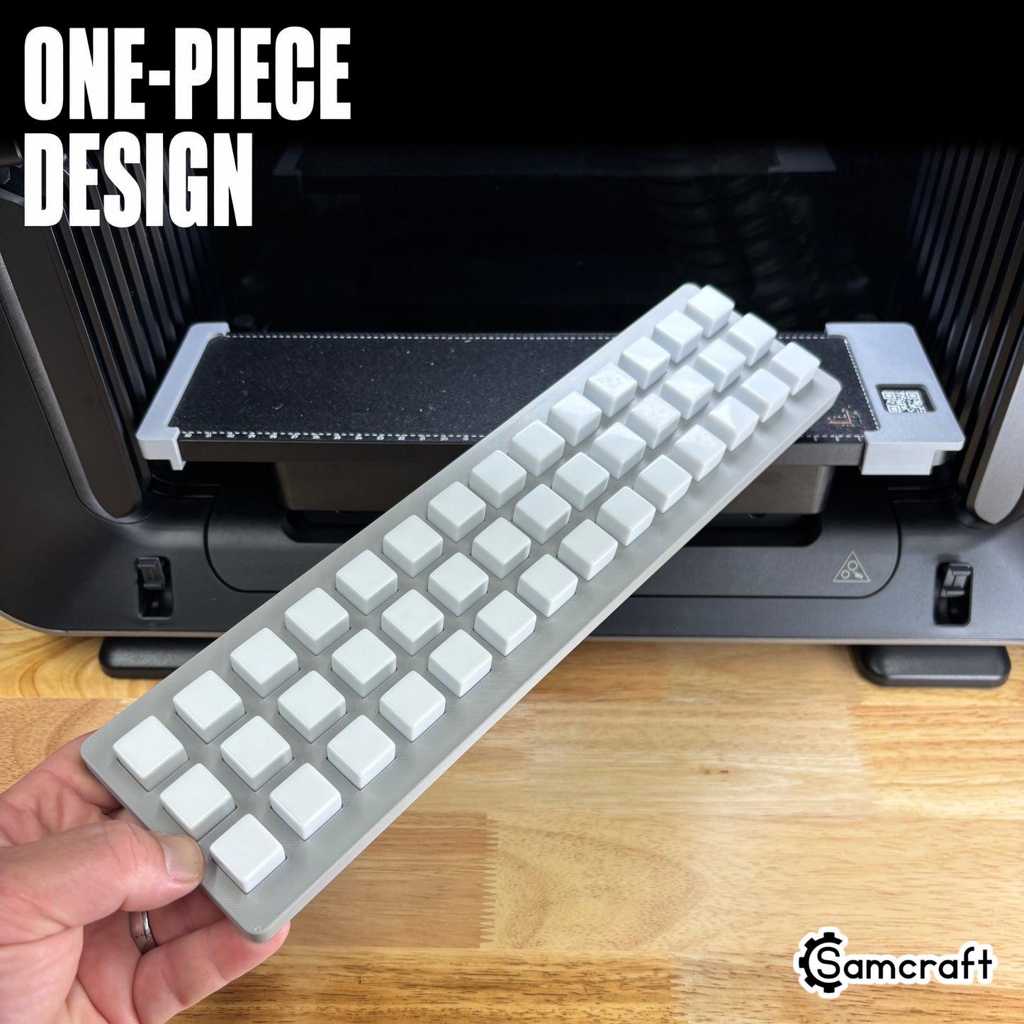 One-piece Samcraft 16mm Dice Jig held in hand above the eufyMake E1 print bed
