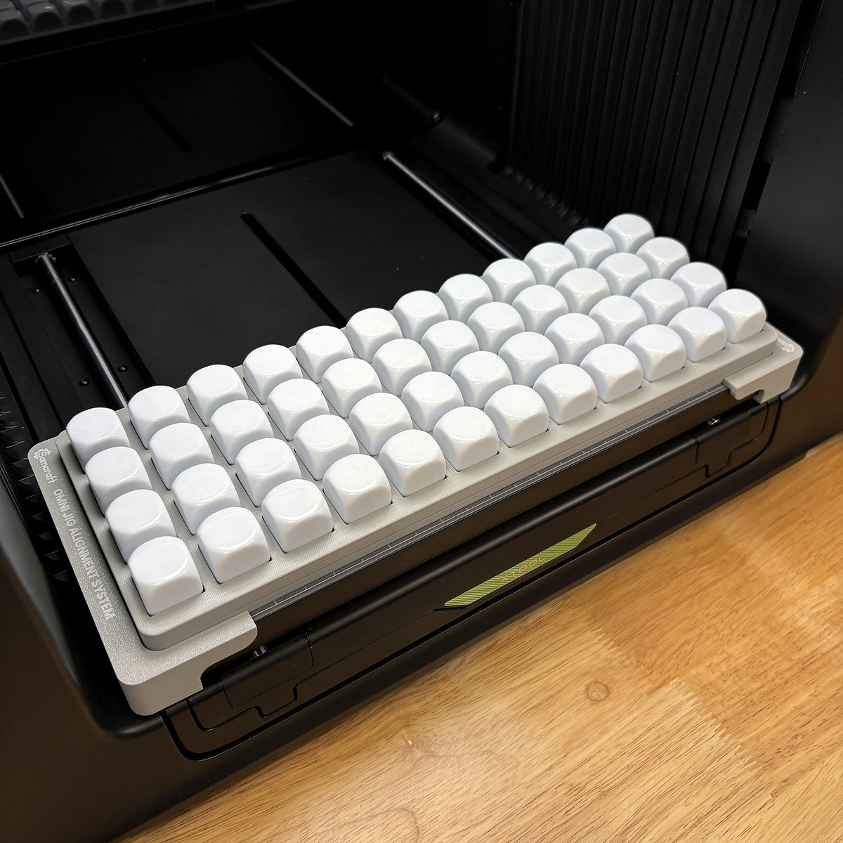 Samcraft 22mm dice jig on the bed of an xTool Omni UV printer, holding 48 large white blank dice in a staggered grid.