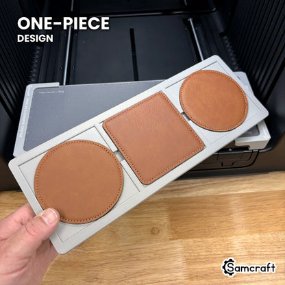 Hand holding the one-piece Samcraft 99mm coaster jig for the xTool Omni, every pocket in a single molded tray.
