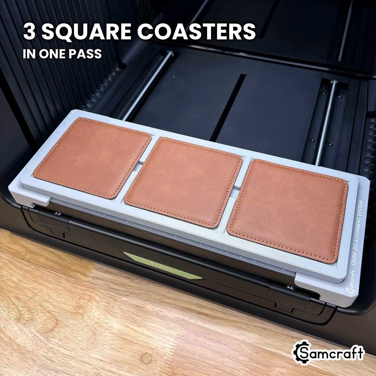 Three square 99mm coasters loaded in the Samcraft xTool Omni jig, a full set of square coasters printed at a time.