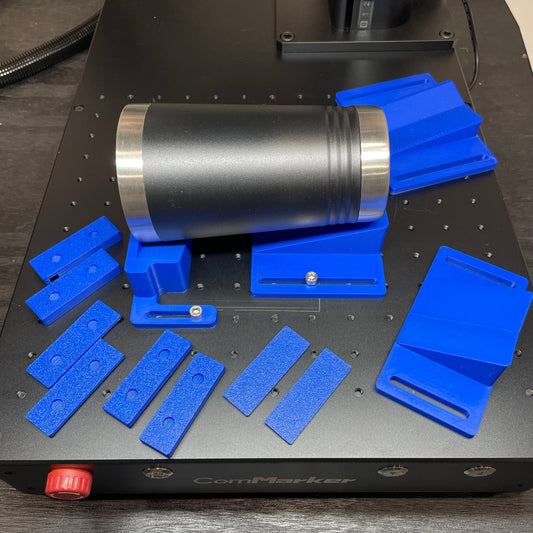 Samcraft blue drinkware jig components laid out on a ComMarker laser bed beside a stainless steel tumbler.