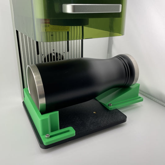 Samcraft green drinkware jig mounted on its black base plate inside an xTool F1, cradling a black stainless steel tumbler.