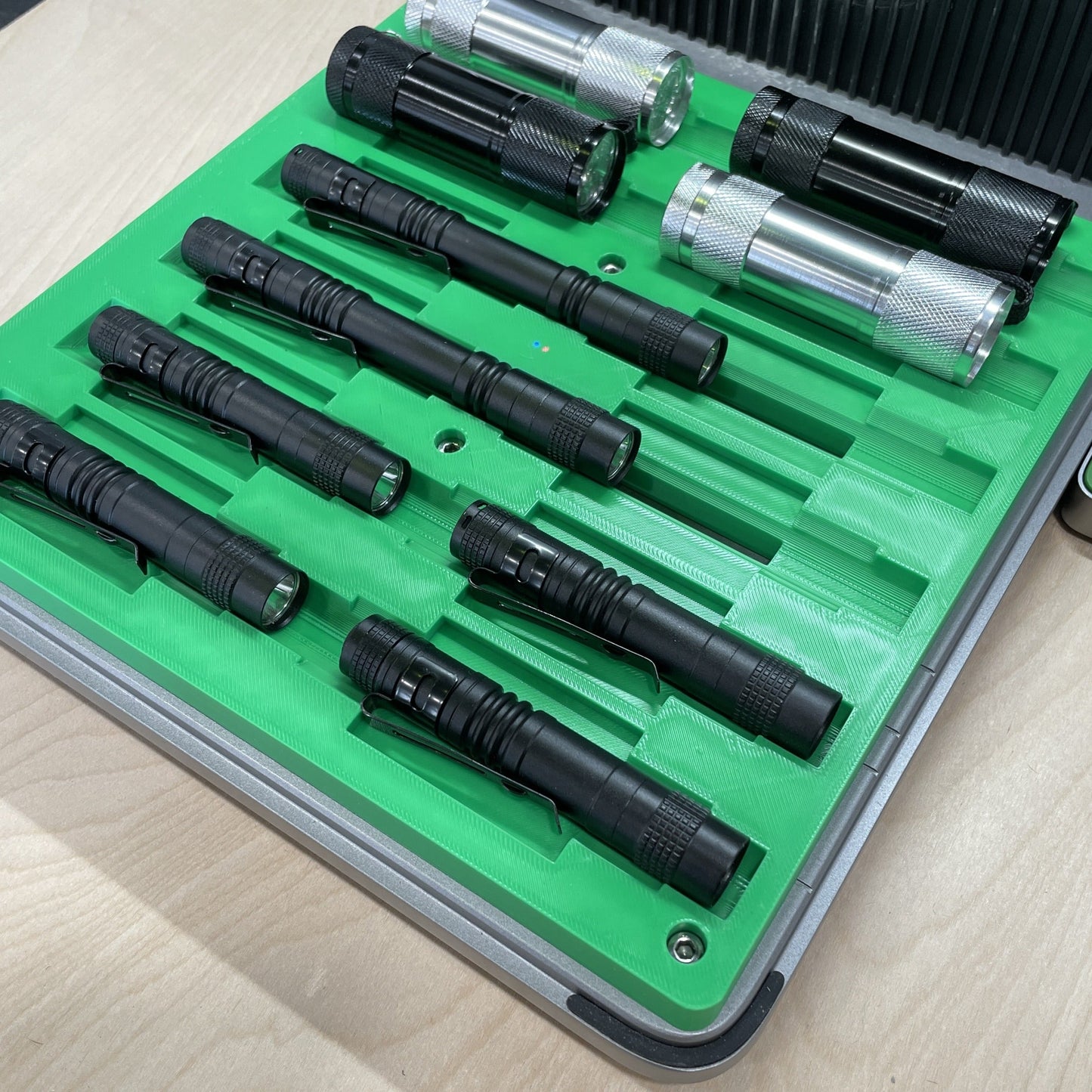 Samcraft green multi flashlight jig in an xTool F1 Ultra laser bed, holding black and clear flashlights in stepped channels.