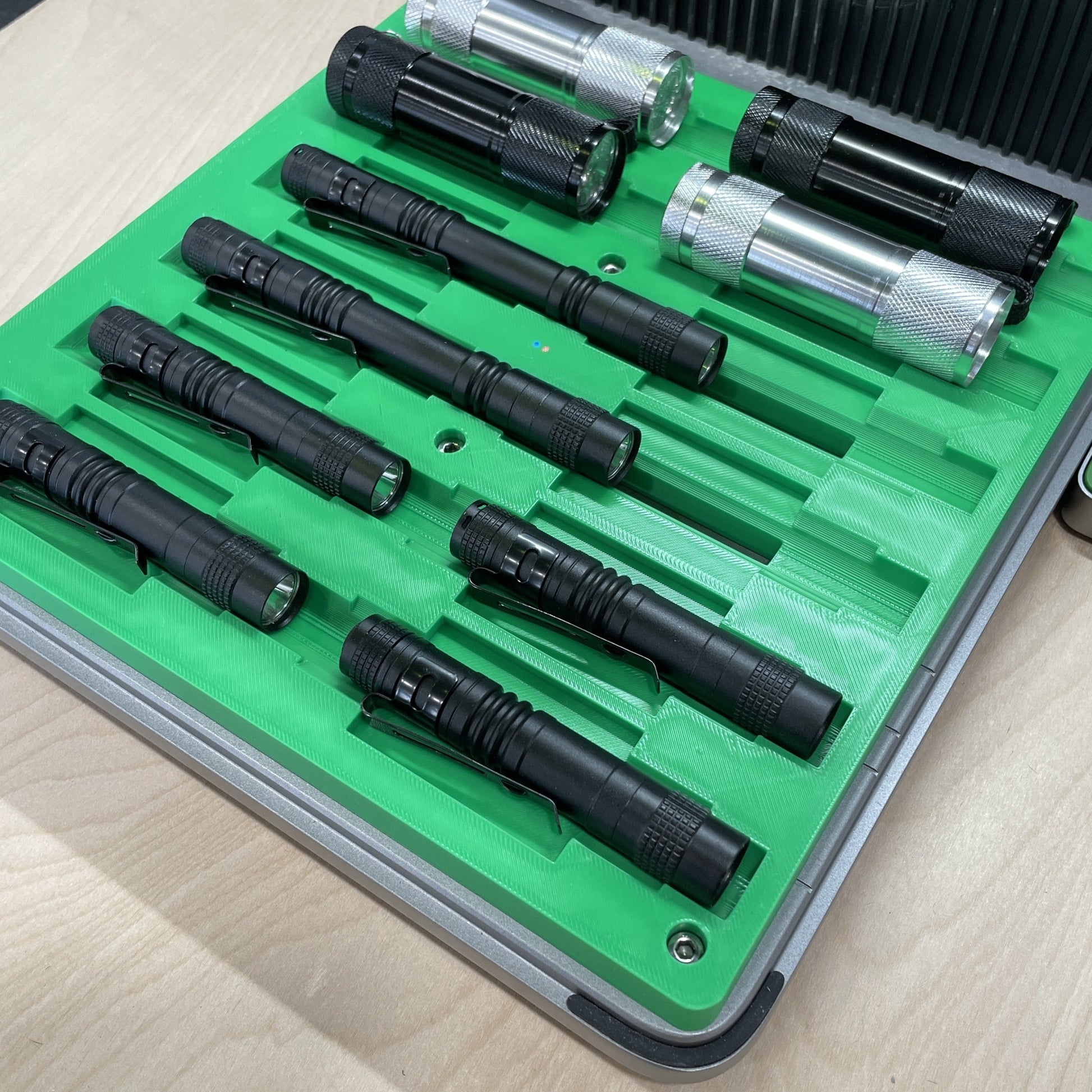 Samcraft green multi flashlight jig in an xTool F1 Ultra laser bed, holding black and clear flashlights in stepped channels.