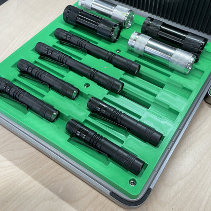 Samcraft green multi flashlight jig in an xTool F1 Ultra laser bed, holding black and clear flashlights in stepped channels.