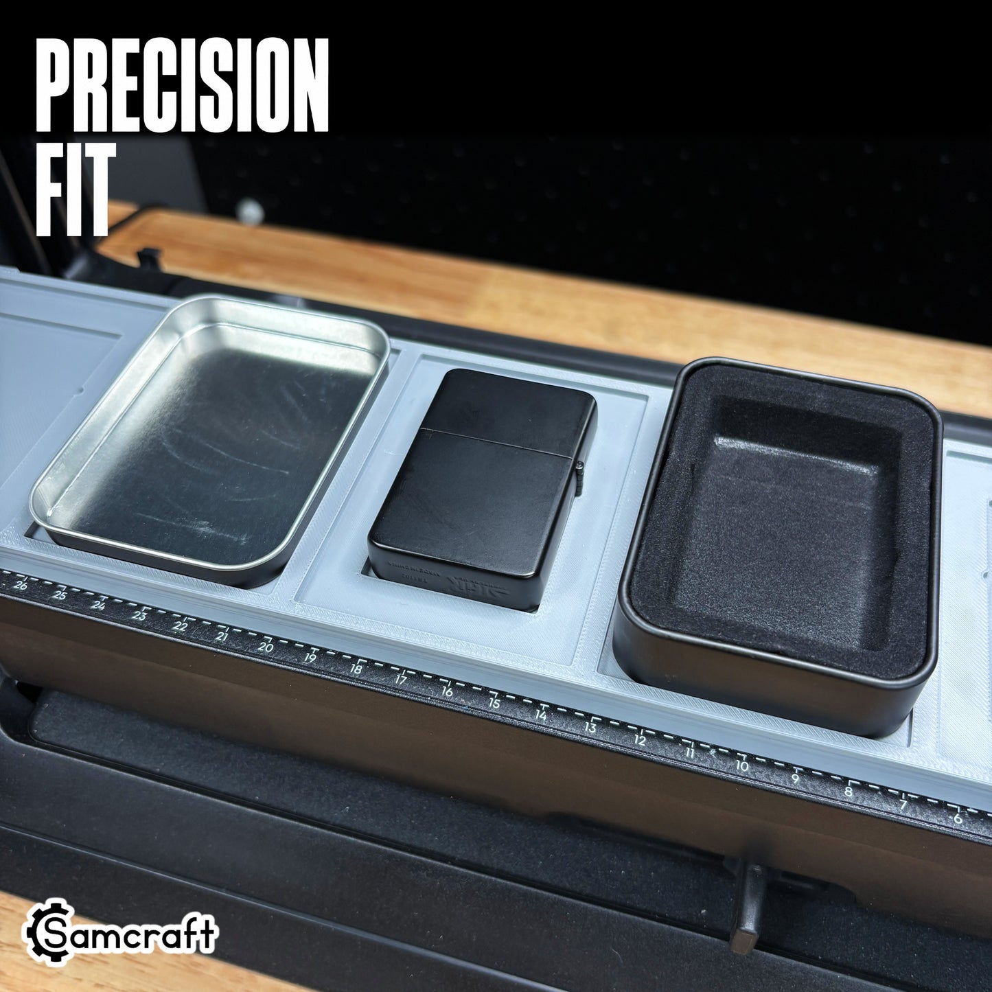 Close-up of the Samcraft jig's precision-fit pockets holding a matte black flip-top lighter and metal tins, showing tight tolerance on the eufyMake E1.