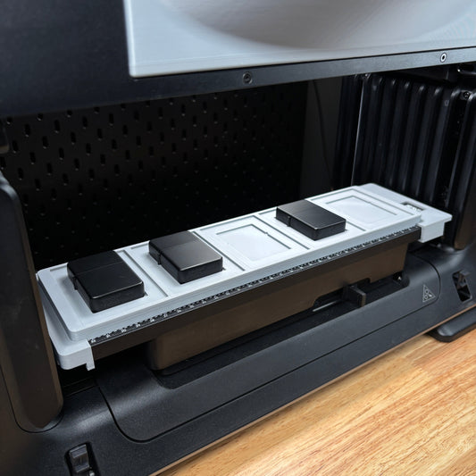 Samcraft flip top lighter jig on the eufyMake E1 print bed, holding a row of black flip top lighters.