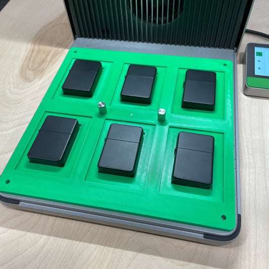 Samcraft green flip top lighter jig in an xTool F1 Ultra laser bed, holding six black flip top lighters.