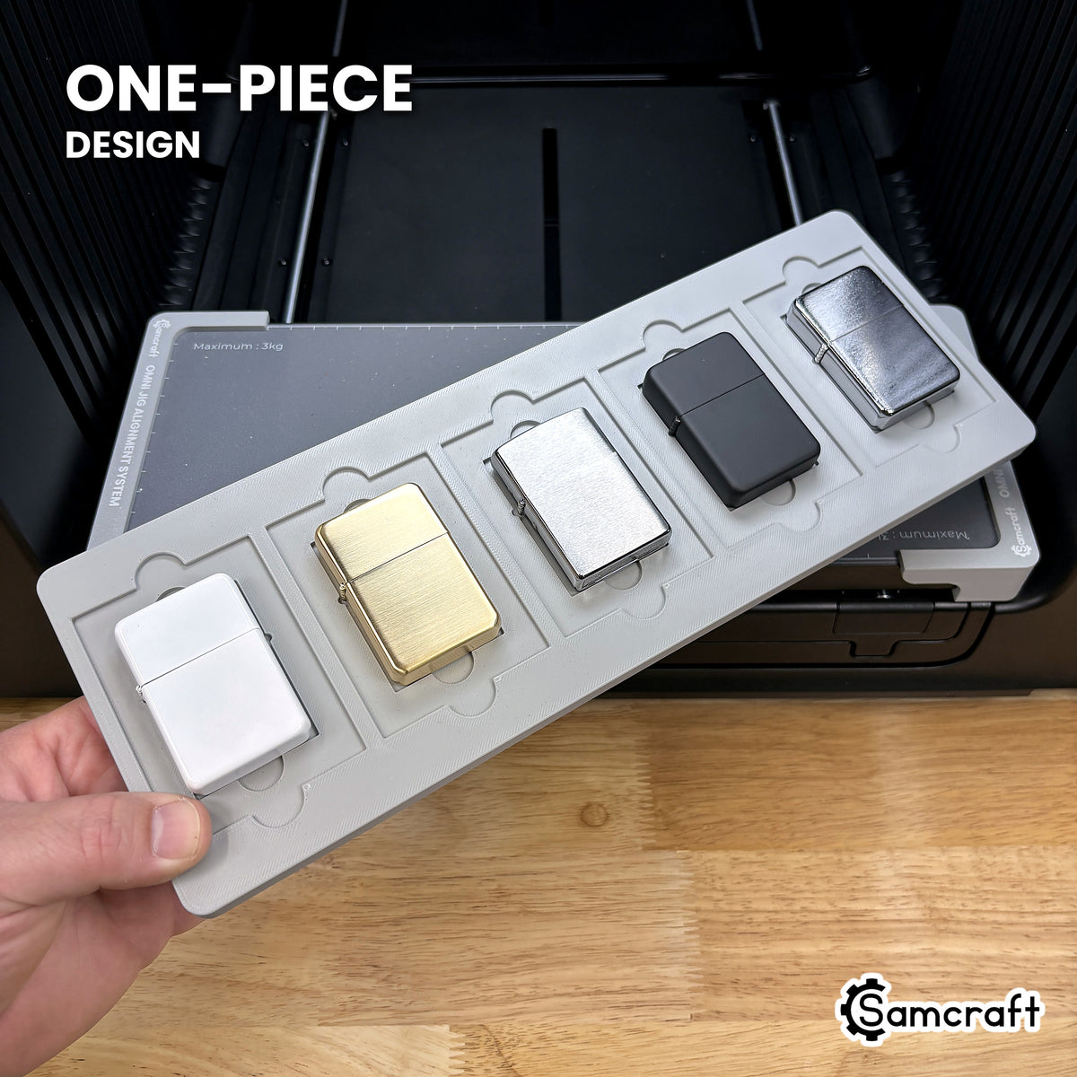 Hand holding the one-piece Samcraft flip top lighter jig for the xTool Omni, five lighters seated in a single molded tray.