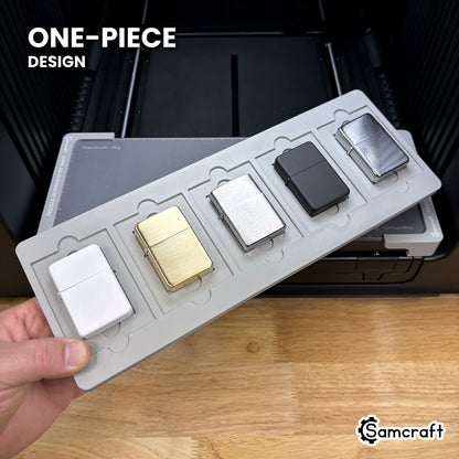 Hand holding the one-piece Samcraft flip top lighter jig for the xTool Omni, five lighters seated in a single molded tray.