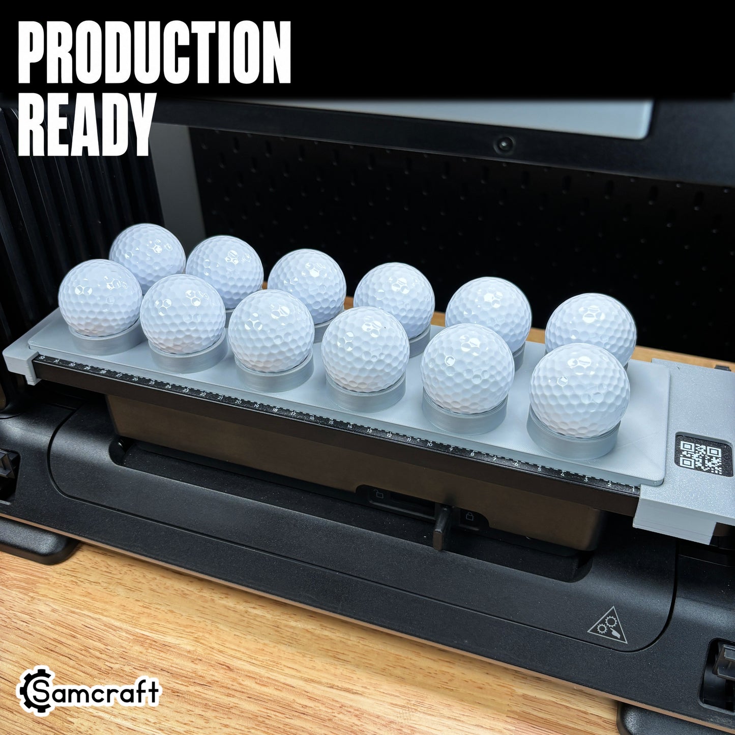 Production-ready Samcraft Golf Ball Jig holding rows of white golf balls in recessed cradles on the eufyMake E1 UV printer bed.