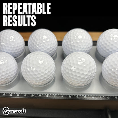 Close-up of white golf balls seated evenly in the Samcraft Golf Ball Jig's cradles, demonstrating repeatable results and the alignment ruler on the eufyMake E1.