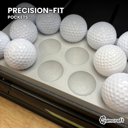 Close-up of the precision-fit ring pockets in the Samcraft golf ball jig for the xTool Omni, with golf balls seated beside empty pockets.