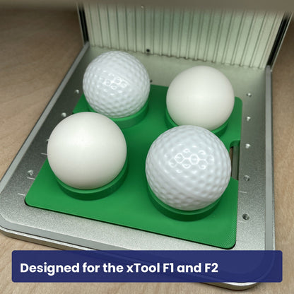 Samcraft ball jig seated in the xTool F1 base plate holding four white balls in its cupped recesses.