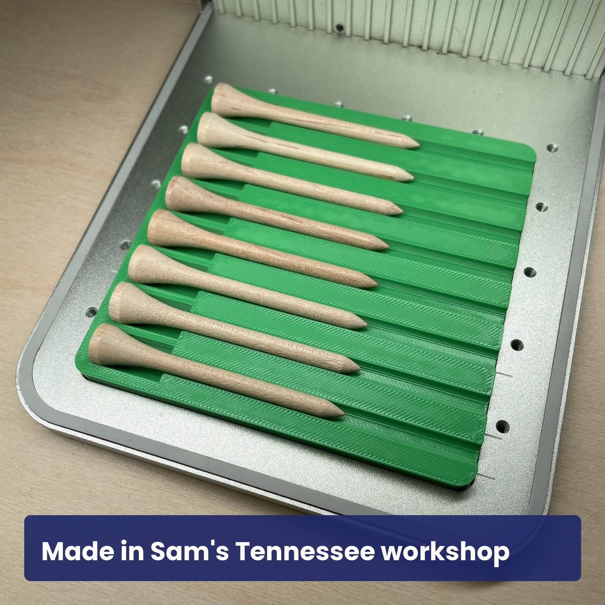 Samcraft golf tee jig in the xTool F1 bed holding a full row of wood golf tees.