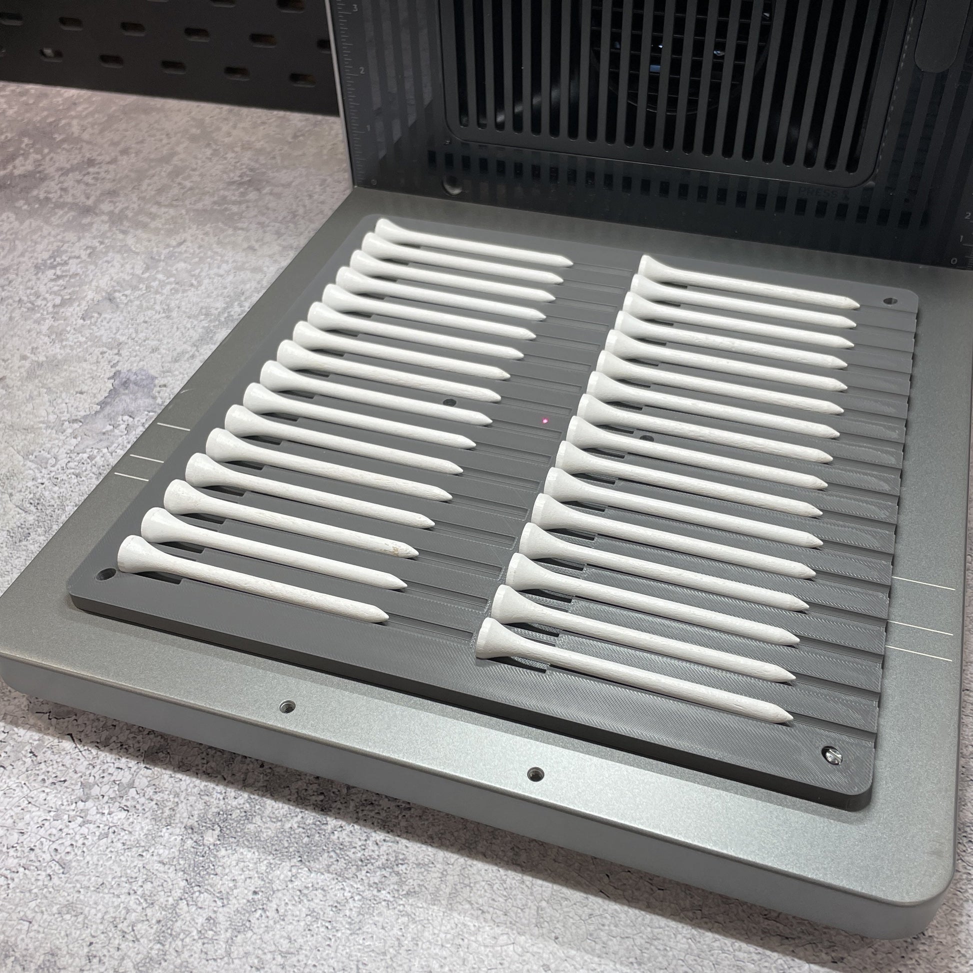 Samcraft golf tee jig on the xTool F2 Ultra bed, holding two full rows of golf tees.