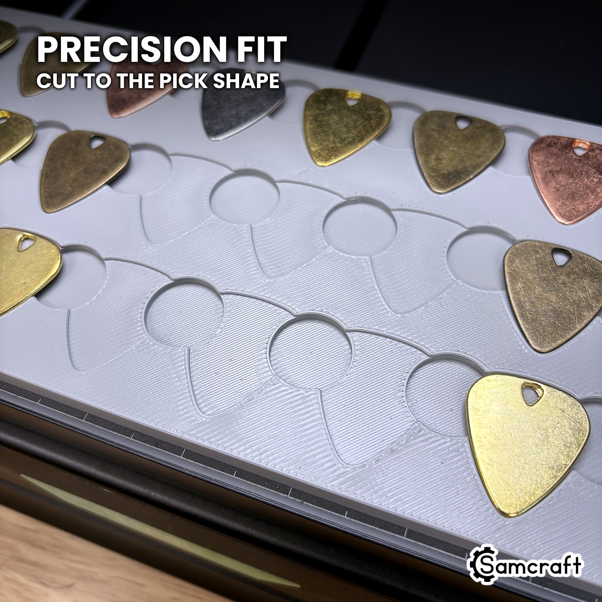 Close-up of the Samcraft xTool Omni guitar pick pockets, each cut to the pick outline so the pick seats without shifting.