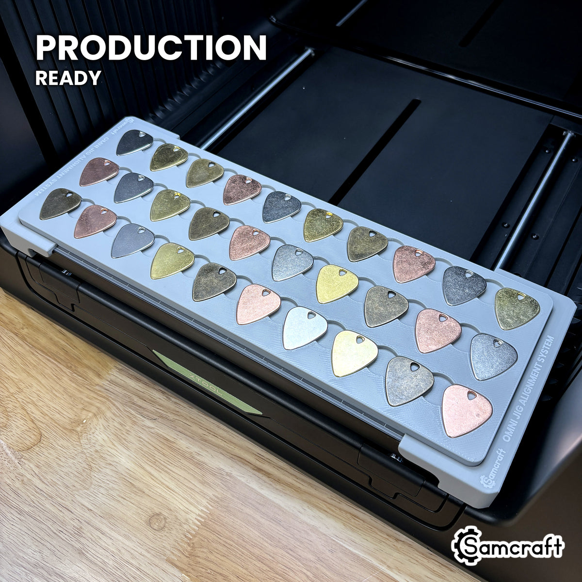 Samcraft guitar pick jig loaded with picks on the xTool Omni UV printer bed, set up for production runs.