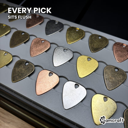 Guitar pick seated flush in the Samcraft xTool Omni jig pocket, level with the surrounding surface.