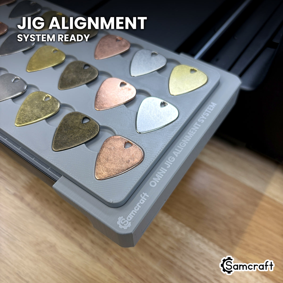 Samcraft guitar pick jig seated on the optional Samcraft Omni Jig Alignment System, the alignment system lettering visible along the edge.